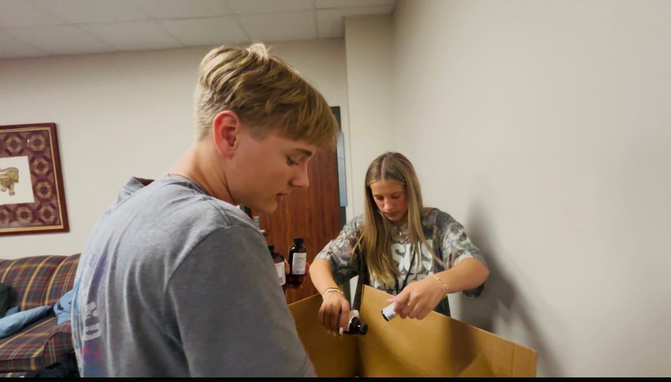 Team members bottling product into a box